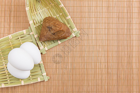 文化底纹端午节竹垫上粽子与蛋背景