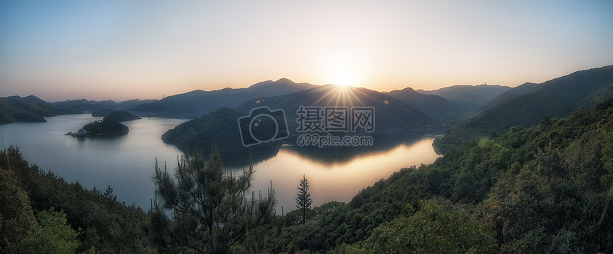 湖边远山的太阳星芒图片