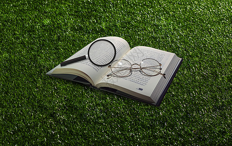 眼镜看书草地风格放大镜和书设计图片