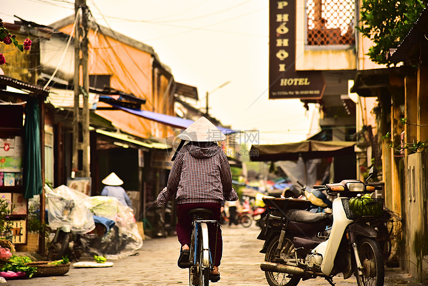 越南会安街上戴尖斗笠的妇人背影图片