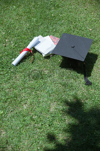 大学草地上的书本证书学士帽图片