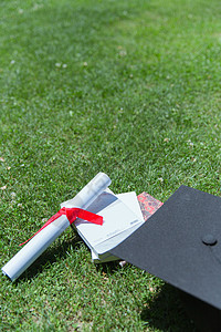 抛学士帽大学草地上的书本证书学士帽背景