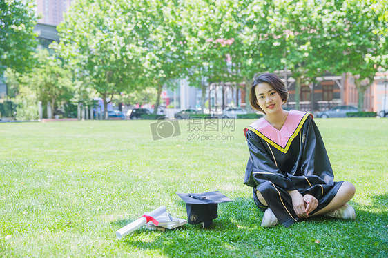 坐在草地上清新学士服女学生图片