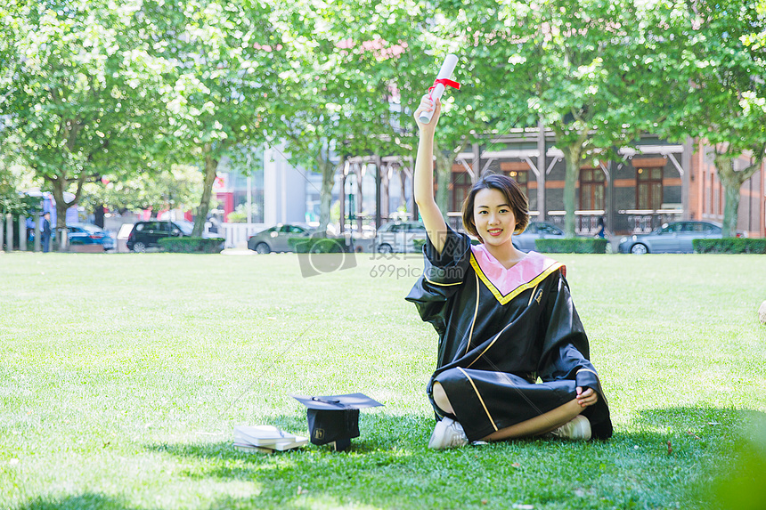 坐在草地上清新学士服女学生图片