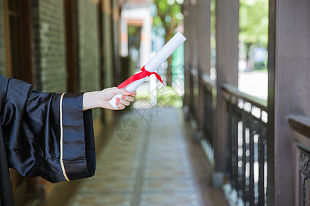 穿学士服女孩教室走廊前手拿证书的毕业生背景