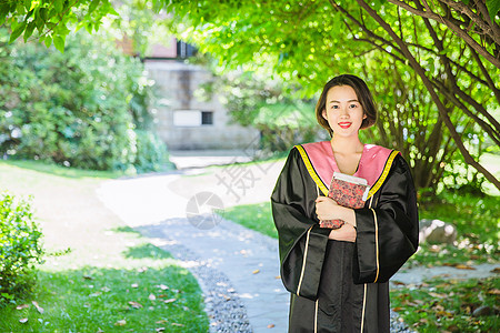 毕业季穿学士服抱书的学生高清图片