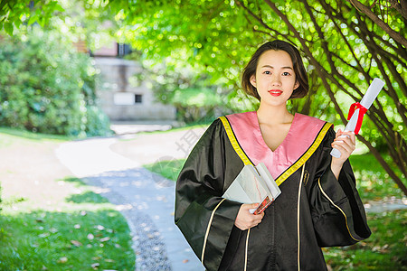 穿学士服的美女毕业季穿学士服抱书的学生背景