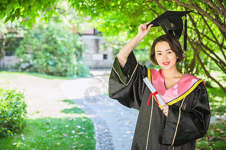 毕业校园树林穿学士服的女学生背景图片