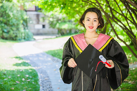 毕业校园树林穿学士服的女学生背景图片