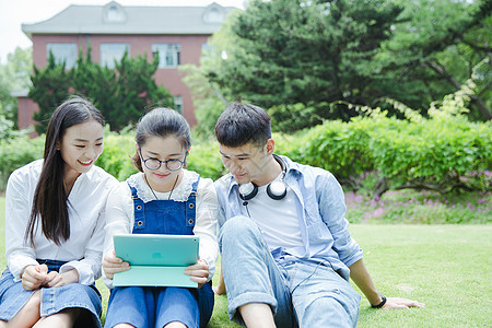 阳光下男女大学生在看平板电脑图片