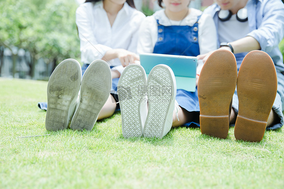 男女大学生看平板电脑鞋子特写图片