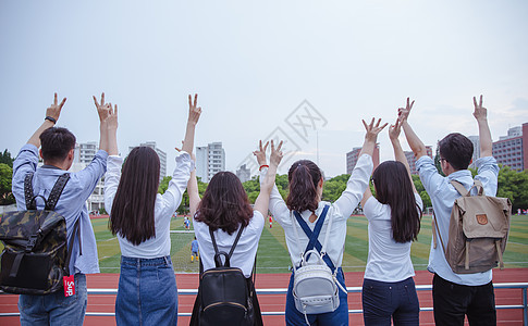 毕业季操场上青春大学们举手比耶背景图片