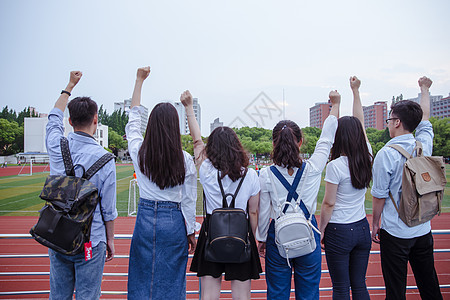 校园举手女生操场上青春活力大学们举手握拳背景