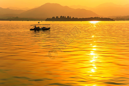 西湖日出金色夕阳洒满湖面背景