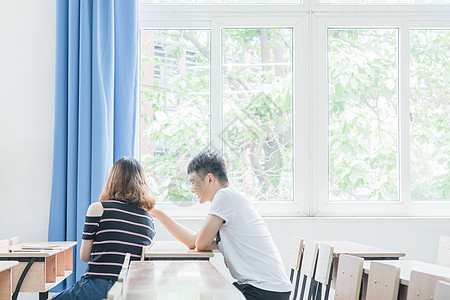 相互交谈的情侣教室里相互交流学习的同学背景