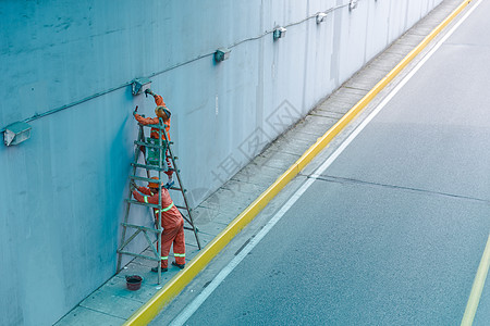 公路施工校园旁马路工人在抢修设备背景