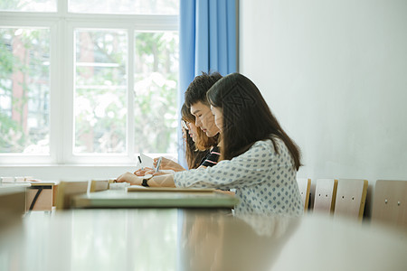 在窗户前的男孩校园教室同学们在写卷子背景