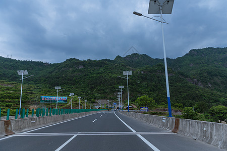 多云天气大气依山隧道前公路图片