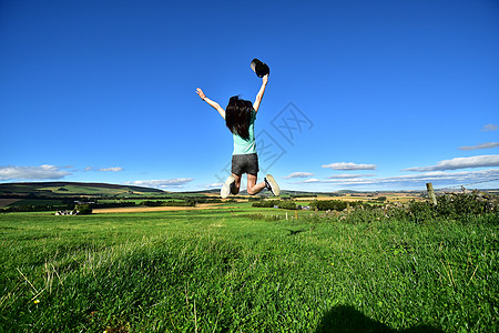草地上跳跃的女孩高清图片