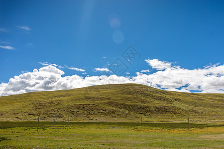 蓝天白云下的草原山峦高清图片