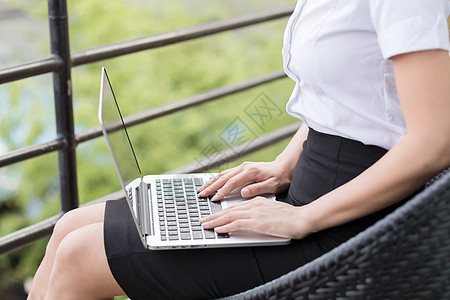 坐着操作笔记本电脑的商务女性图片