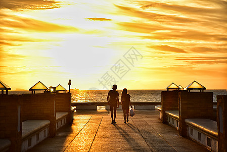 漫步海边泰国苏梅岛码头黄昏夕阳日落海边的情侣背景