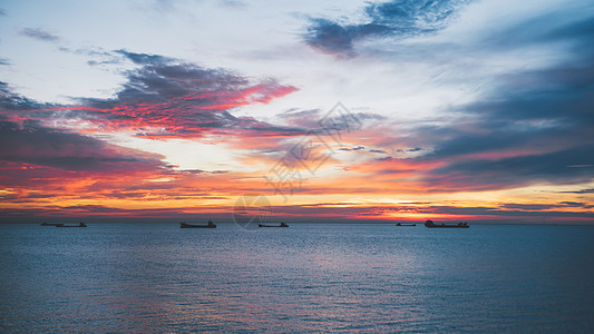 日出天空海边船舶背景图片