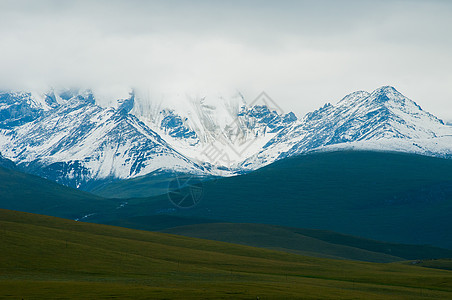 云绕雪山顶新疆雪山雪峰草原云雾背景