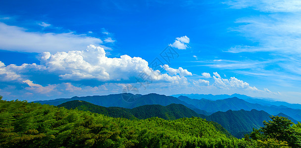 蓝天白云下的山峦叠嶂图片