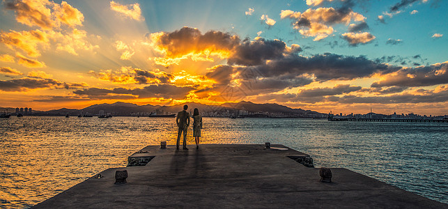 海边观落日夏天情侣海边高清图片