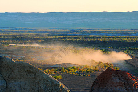 新疆荒漠中尘土飞扬疾驰的越野车背景图片