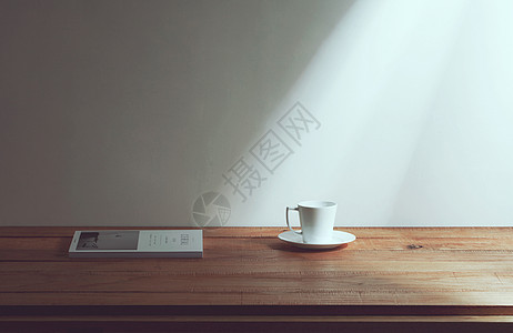 方形木纹桌上的咖啡杯和杂志背景