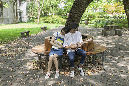 学校绿荫下男女同学在一起学音乐恋爱图片