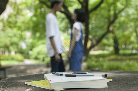 学校学生在绿荫下恋爱还有书本背景图片