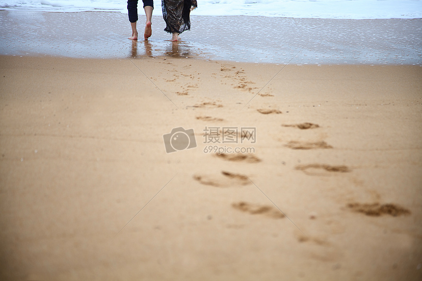 一对情侣在沙滩上行走图片