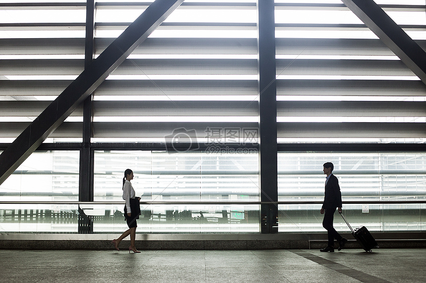 商务男士和商务女士在机场通道会晤握手图片