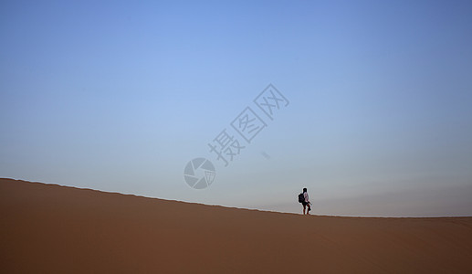 旅行中一个人孤独的在沙漠上行走图片