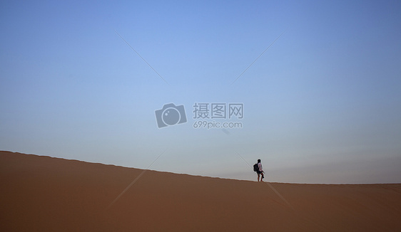 旅行中一个人孤独的在沙漠上行走图片