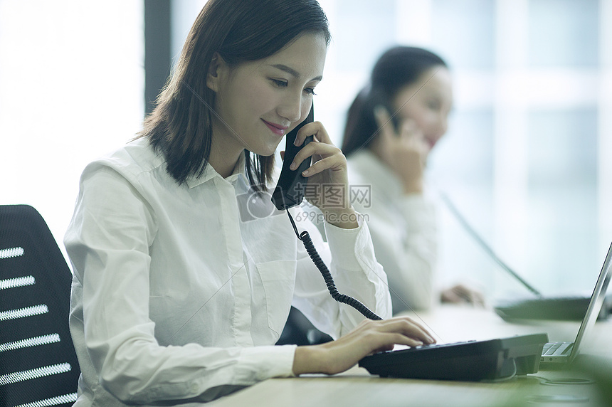 商业大厦里客服白领正在接听电话摄影图片免费