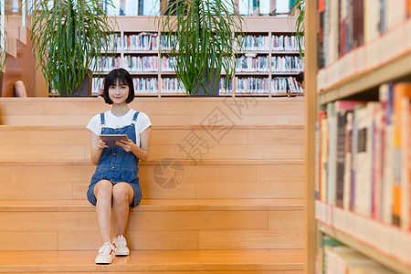 坐在图书馆使用平板的女生图片