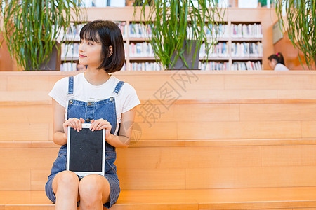 坐在图书馆使用平板的女生高清图片