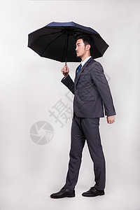 撑着伞的商务人士图片