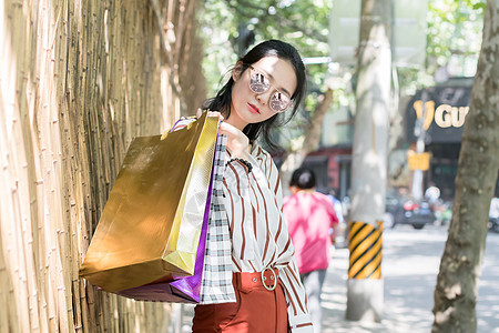 女性提着购物袋时尚女生逛街购物街拍背景