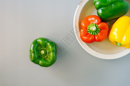 一盘红椒黄椒和青椒背景图片