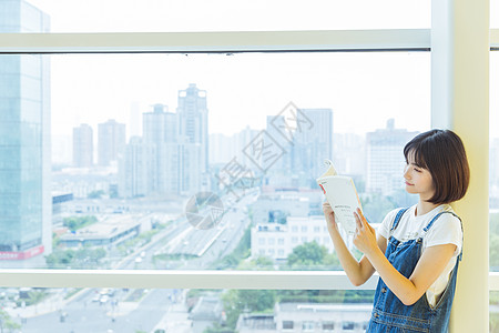 户外休息区大学女生教学楼学习看书背景