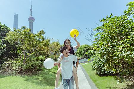情人节公园情侣背起玩气球高清图片