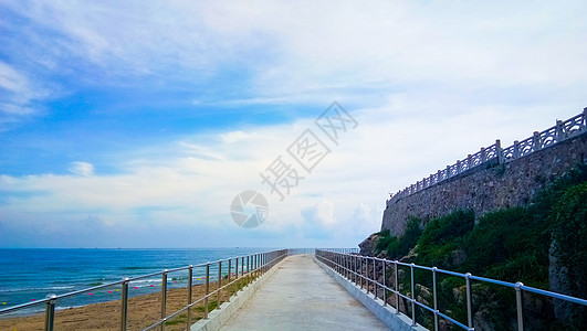 蓝天白云下的海边道路背景图片