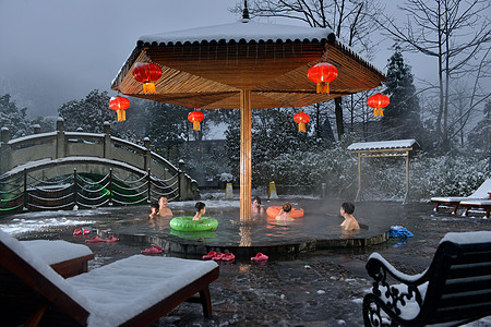 雪小孩在冰天雪地里享受热气腾腾的温泉背景