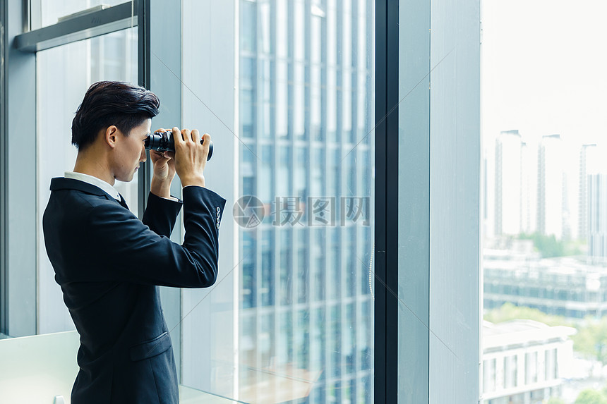 商务人士用望远镜观察图片