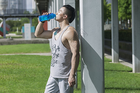 锻炼健身男孩男孩在户外运动后喝运动饮料背景